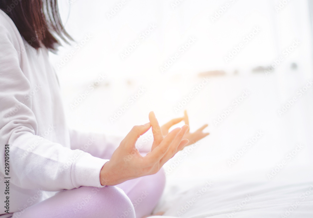Asian girls sitting on yoga poses in bed in a warm morning.Yoga on the bed at dawn Good for the body and the mind.Warm tone.Do not focus on objects. Asian girls sitting on yoga poses in bed in a warm morning.Yoga on the bed at dawn Good for the body and the mind.Warm tone.Do not focus on objects.