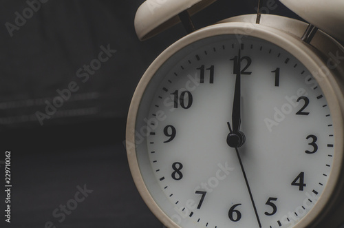 Close up.White Alarm clock isolated Placed on a Black background. copy space.
