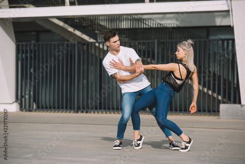 young couple of contemporary dancers practicing on urban city street