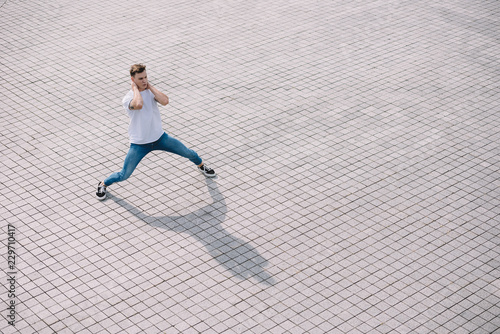 high angle view of handsome young man dancing on city street