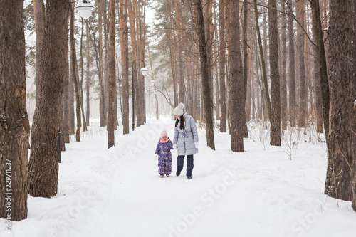 Motherhood, children and nature concept - Attractive young woman and adorable child walking in park © satura_