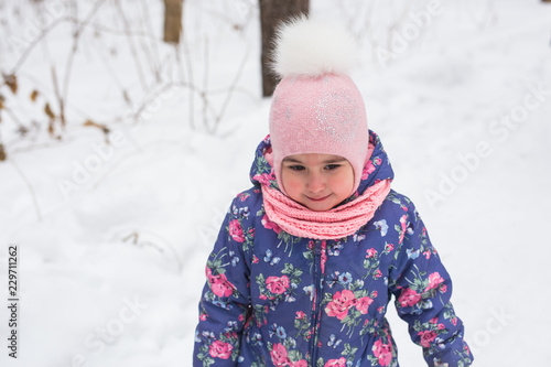 Childhood and children concept - baby girl walk in the winter outdoors