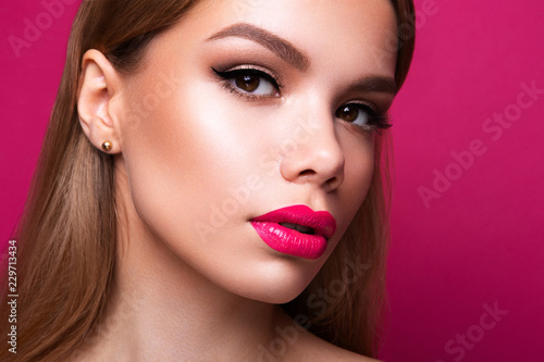 Close-up portrait of beautiful woman with bright make-up and pink lips