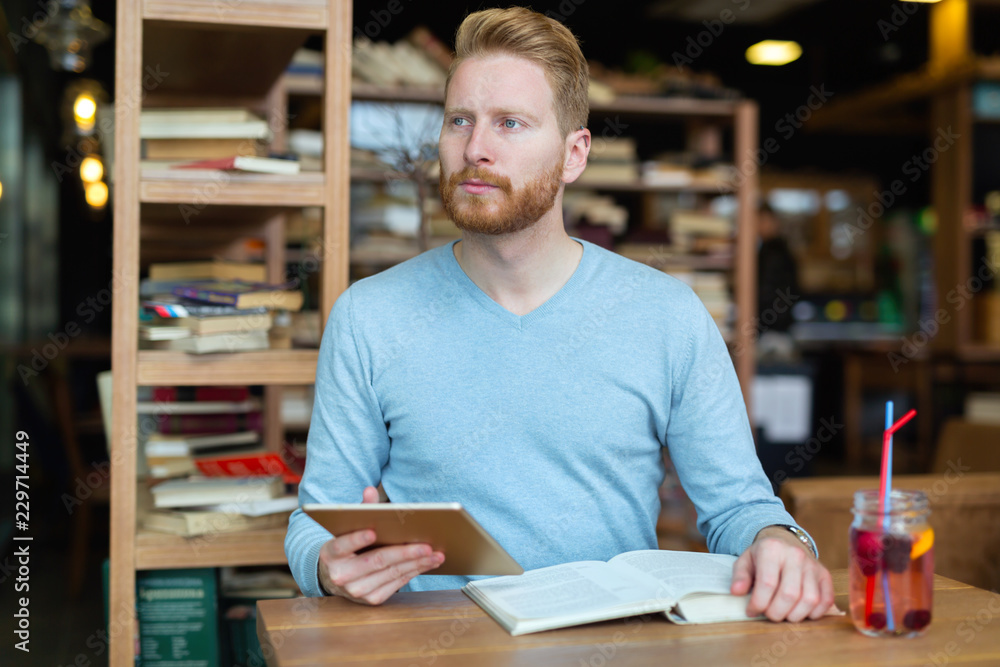 Young handsome student learning in coffee shop Young handsome student learning in coffee shop