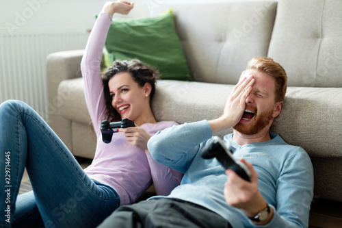 Happy couple playing video games at home