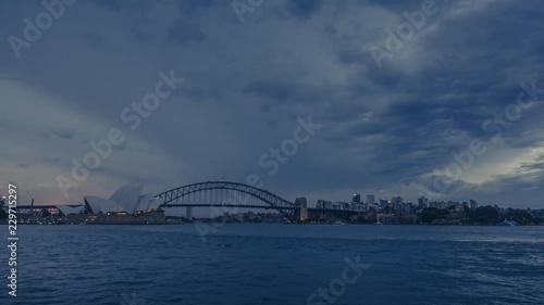 Timelapse of nightfall in Sydney, Australia with its most iconic building - Sydney Opera House and Sydney Harbour Bridge. Smooth transition from daylight to night with bright lights of the city.  photo