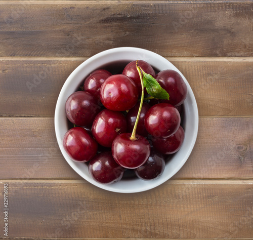 Cherry fruit. Cherries with copy space for text. Top view. Background of cherries. Ripe and tasty cherries on a wooden background.