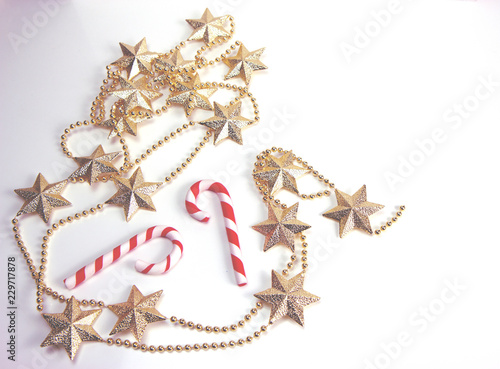 Golden stars and two red and white candy canes. Christmas and New Year holiday background concept. Copy space for text