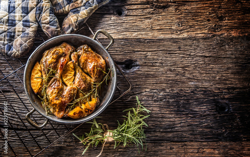 Roasted duck legs in pan with oranges herbs red cabbage and potato pankaces photo