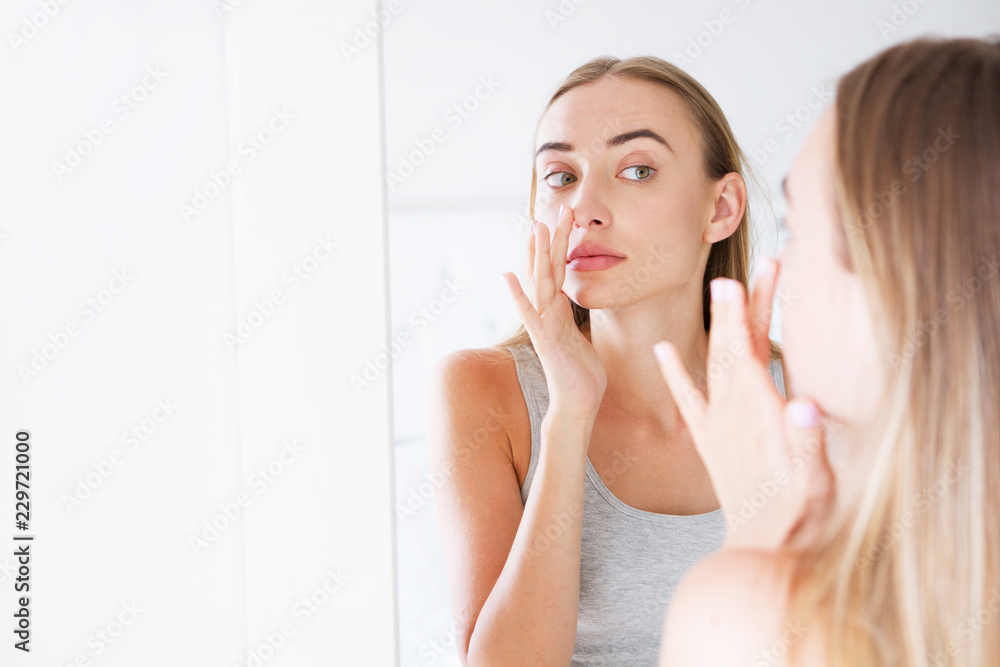 pretty girl, woman touching her nose while looking in the mirror, beauty concept,plastics pretty girl, woman touching her nose while looking in the mirror, beauty concept,plastics