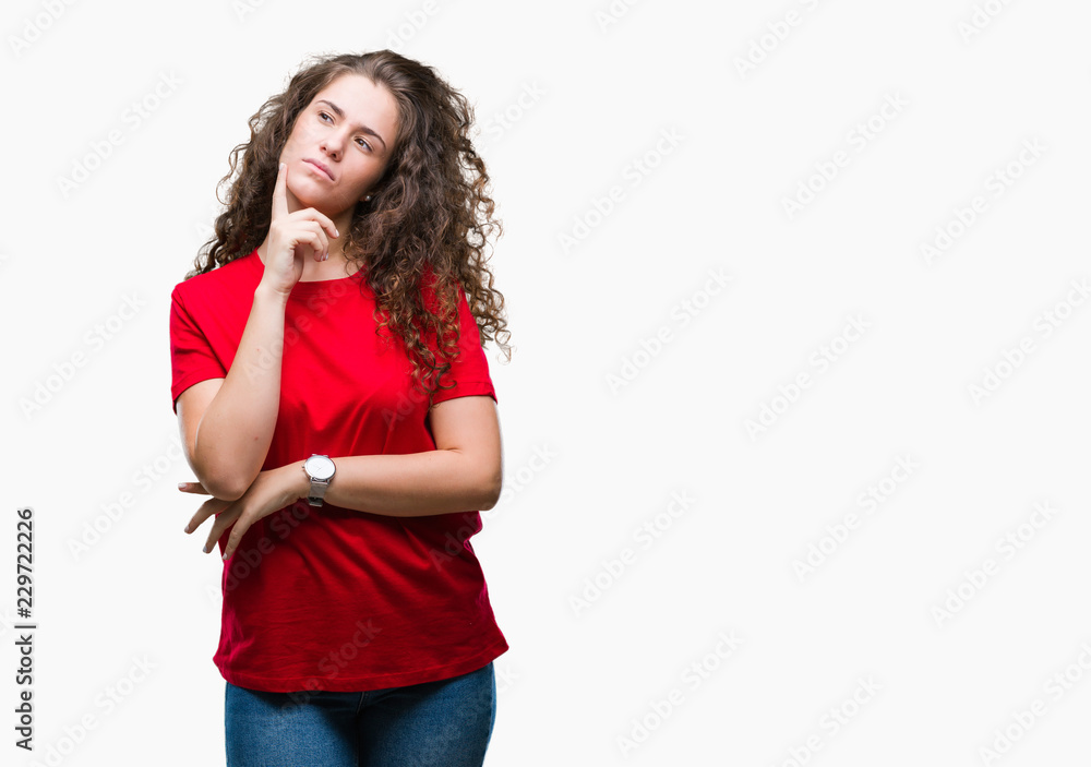 Beautiful brunette curly hair young girl wearing casual look over isolated background with hand on chin thinking about question, pensive expression. Smiling with thoughtful face. Doubt concept.