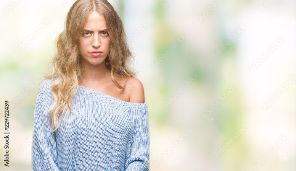 Beautiful young blonde woman wearing winter sweater over isolated background skeptic and nervous, frowning upset because of problem. Negative person. Beautiful young blonde woman wearing winter sweater over isolated background skeptic and nervous, frowning upset because of problem. Negative person.