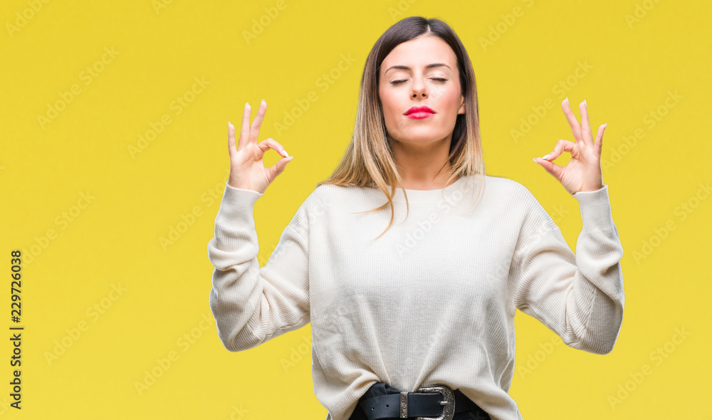 Young beautiful woman casual white sweater over isolated background relax and smiling with eyes closed doing meditation gesture with fingers. Yoga concept. - obrazy, fototapety, plakaty 