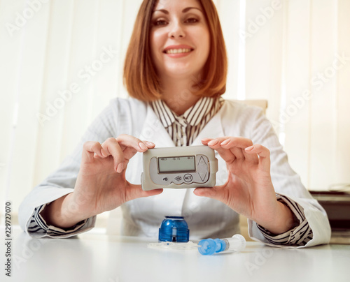 Doctor holding the insulin pump at his hands.