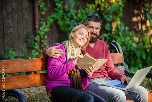 Couple with book and laptop search information. Share or exchange information knowledge. Information source concept. Man and woman use different information storage. Couple spend leisure reading