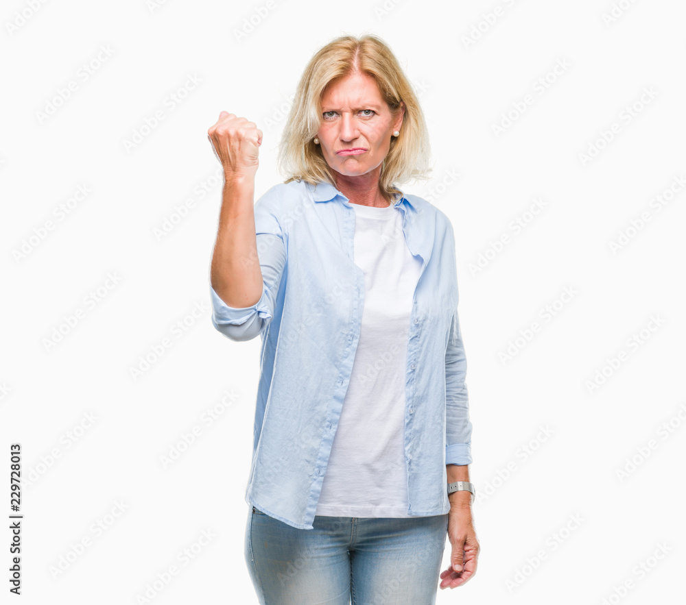 Middle age blonde woman over isolated background angry and mad raising fist frustrated and furious while shouting with anger. Rage and aggressive concept. Middle age blonde woman over isolated background angry and mad raising fist frustrated and furious while shouting with anger. Rage and aggressive concept.