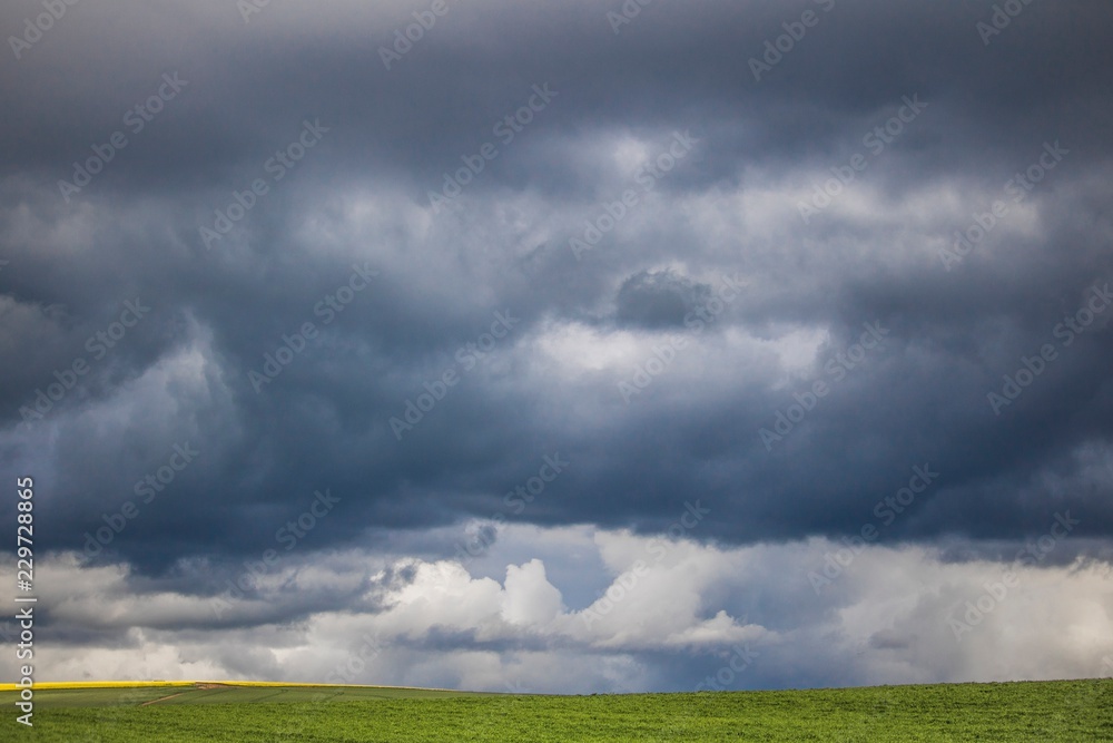 Minimalism photo of a dramatic clouds over a green field. Minimalism photo of a dramatic clouds over a green field.