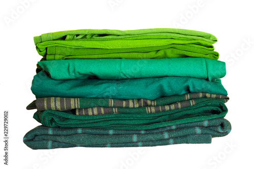 Stack green winter clothes isolated on white background