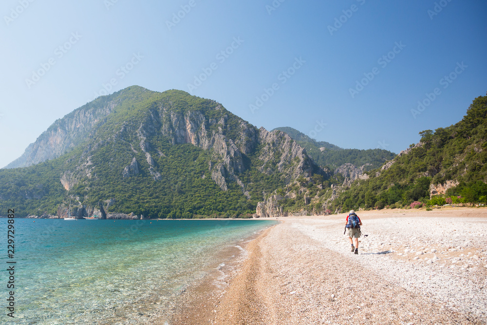 Individual man hiking along beach in Cirali, Turkey.