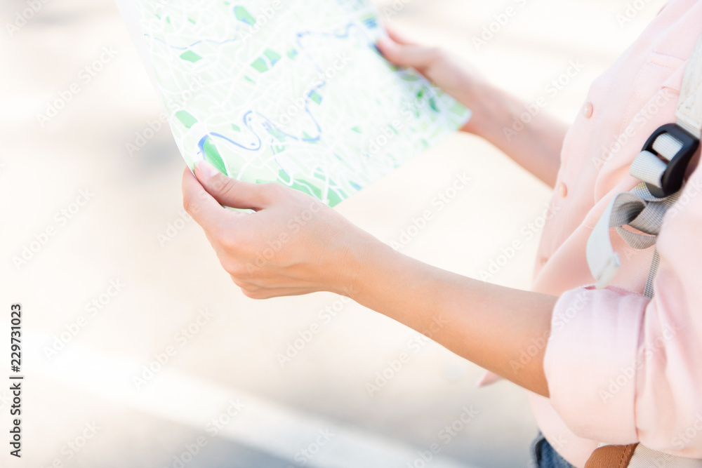 Obraz premium cropped image of traveler holding city map on street
