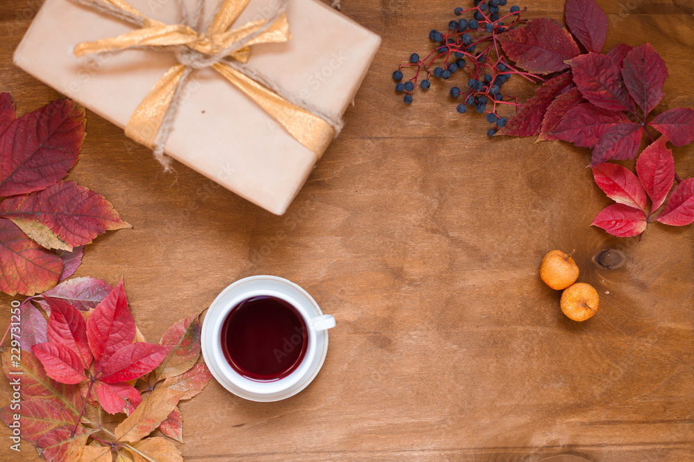 Autumn leaves a cup of tea and coffee gift on wooden background