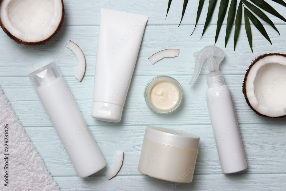 Tropical leaf, care cosmetics and coconut on a wooden table. Top view. Means for hair, body, skin. flatlay Tropical leaf, care cosmetics and coconut on a wooden table. Top view. Means for hair, body, skin. flatlay