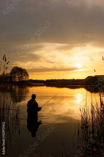 Angler catching the fish during sunset