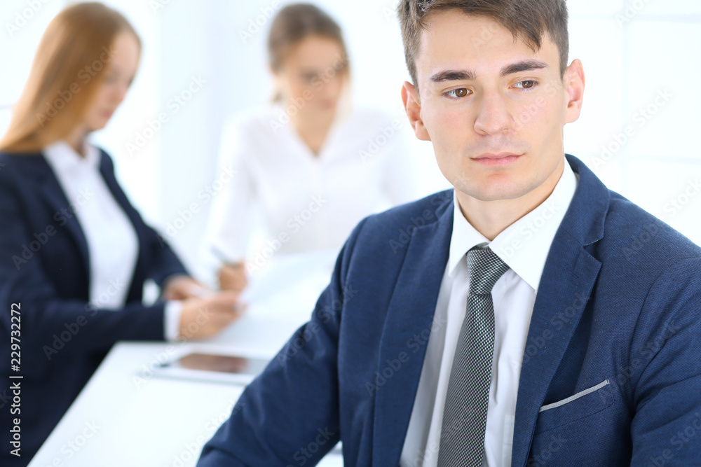 Group of business people or lawyers discussing terms of transaction in office. Focus at young businessman. Meeting and teamwork concept Group of business people or lawyers discussing terms of transaction in office. Focus at young businessman. Meeting and teamwork concept