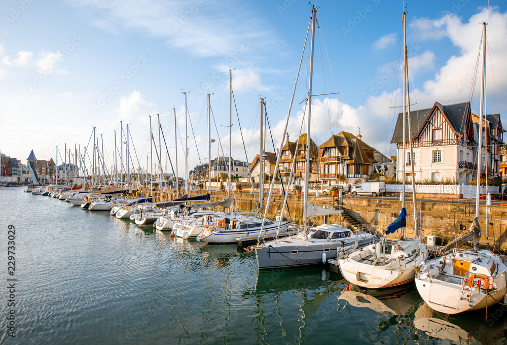 Landscape view on the harbour with beautiful yachts and buildings during the morning light in Deauvillle village in France