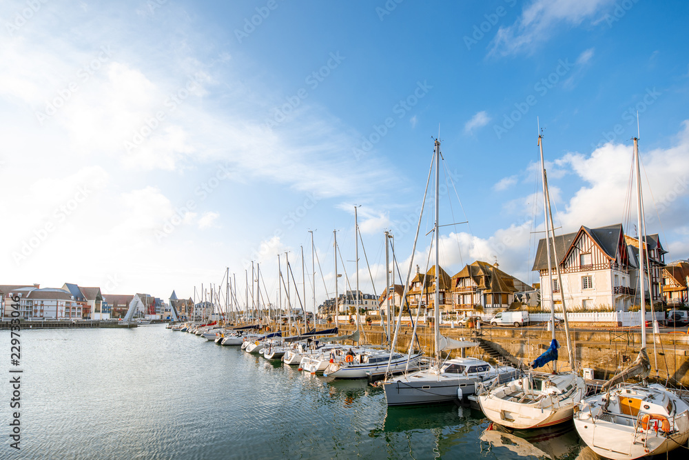 Landscape view on the harbour with beautiful yachts and buildings during the morning light in Deauvillle village in France