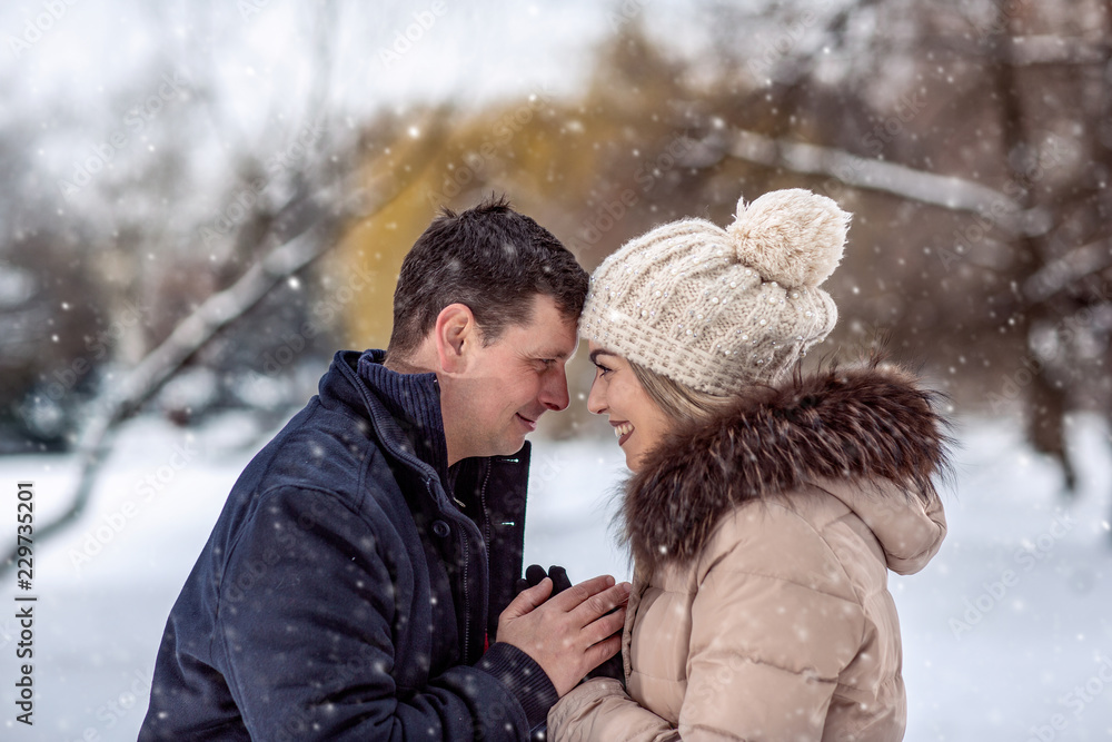 Loving couple enjoying together during winter holidays vacation outside in snow park.