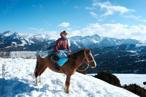 A man is a cowboy on a horse. Winter. the mountains.