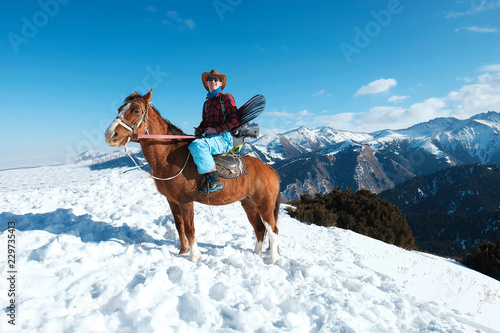 Freeride. A man in a cowboy hat riding a horse in the snow. Winter. the mountains.