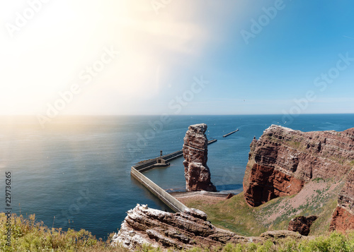 famous sea stack Lange Anna on island of Heligoland against blue sea and sky on sunny day photo