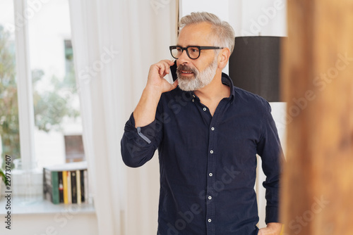 Senior man talking on a mobile phone indoors
