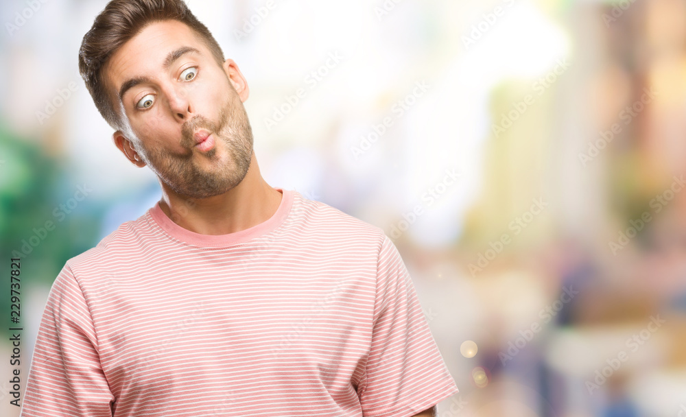 Young handsome man over isolated background making fish face with lips, crazy and comical gesture. Funny expression. Young handsome man over isolated background making fish face with lips, crazy and comical gesture. Funny expression.