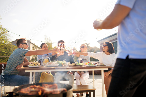 Photography leisure and people concept - happy friends toasting drinks at barbecue party on