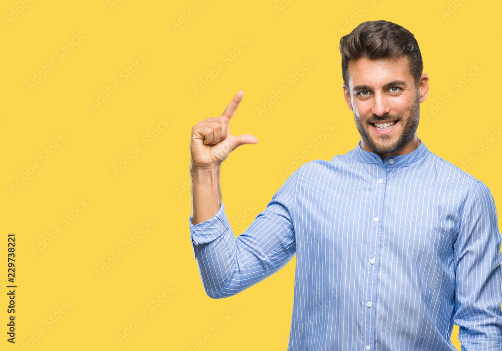 Young handsome man over isolated background smiling and confident gesturing with hand doing size sign with fingers while looking and the camera. Measure concept. Young handsome man over isolated background smiling and confident gesturing with hand doing size sign with fingers while looking and the camera. Measure concept.