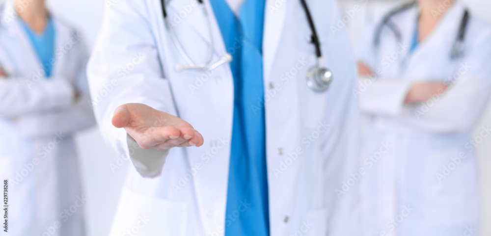 Group of medicine doctors offering helping hand  for shaking hand or saving life closeup. Partnership and trust concept in health care or medical cure 