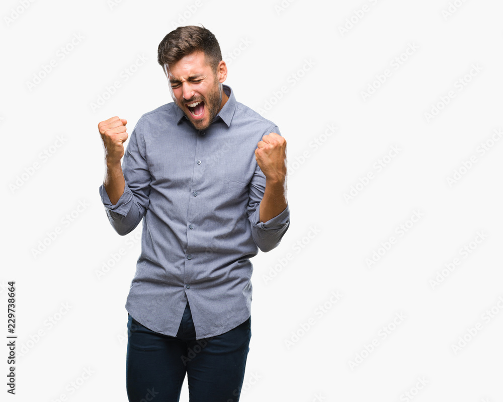 Young handsome man over isolated background very happy and excited doing winner gesture with arms raised, smiling and screaming for success. Celebration concept. Young handsome man over isolated background very happy and excited doing winner gesture with arms raised, smiling and screaming for success. Celebration concept.