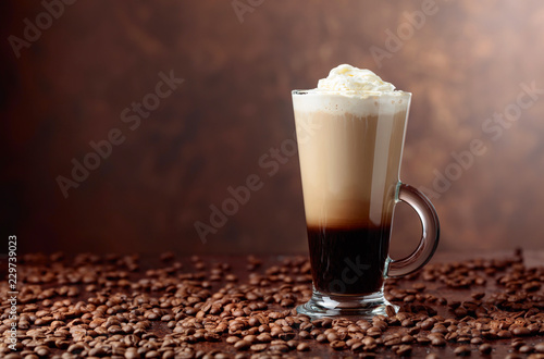 Coffee drink or cocktail with cream on a brown background.