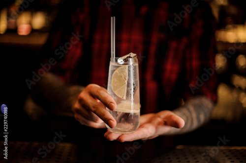 Man holding elegant long drink glass filled with Tom Collins cocktail