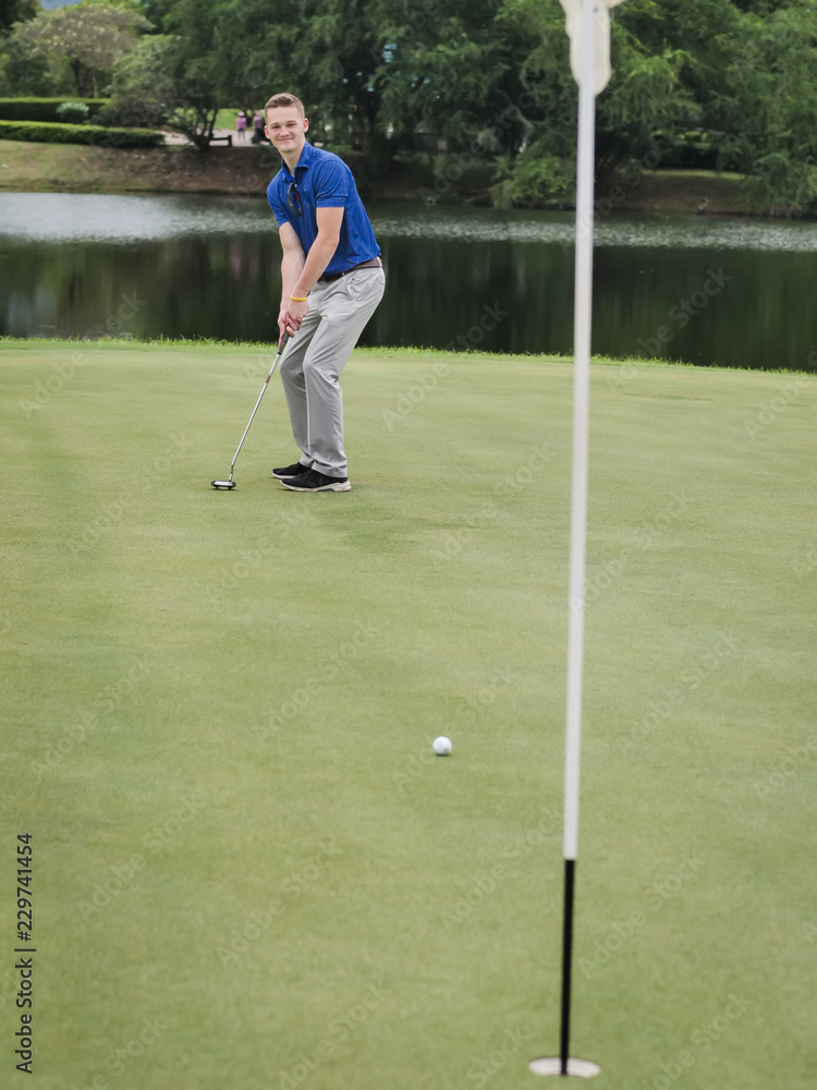 Fototapeta premium Golfer putting golf ball on the green golf in cloudy day.