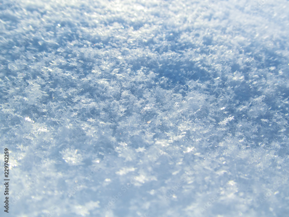 Snow texture with snowflakes close-up. Beautiful winter and Christmas background. Blue macro image of an abstract snowdrift. Snow texture with snowflakes close-up. Beautiful winter and Christmas background. Blue macro image of an abstract snowdrift.