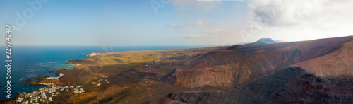 Vista aerea del paese di Orzola e delle coste frastagliate dell’isola di Lanzarote, Isole Canarie, Spagna. Africa. Rilievi a picco sul mare e percorsi sterrati. Sentieri per trekking