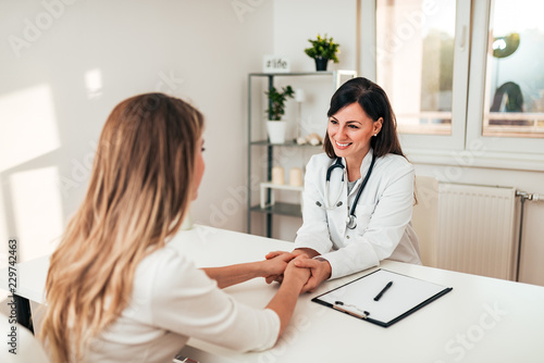  Smiling doctor reassuring her female patient.