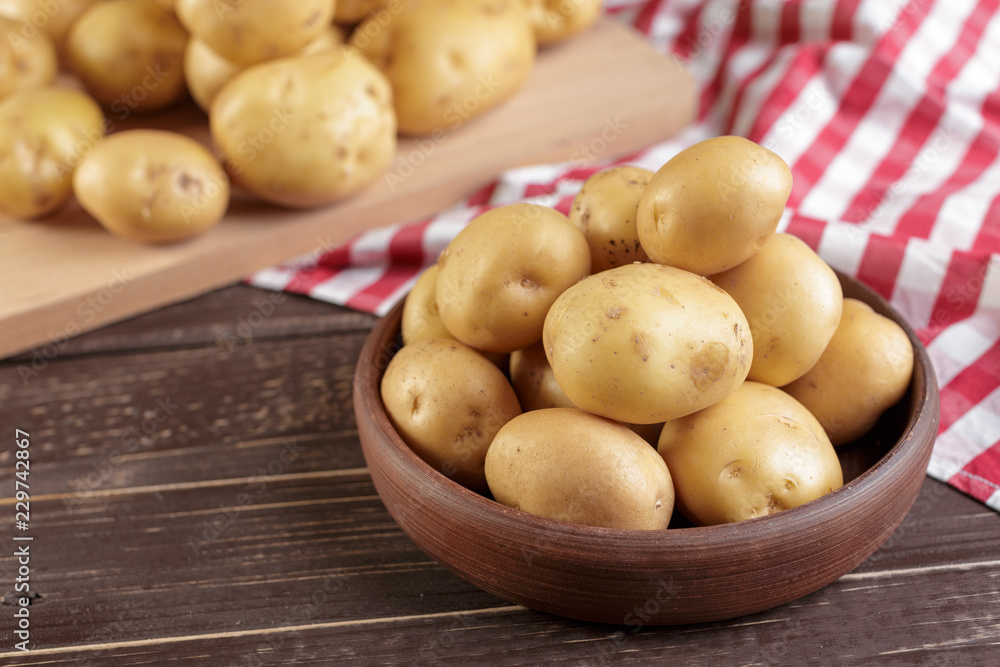 Fresh potatoes on the wood background Fresh potatoes on the wood background