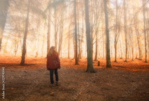 Girl in dreamy autumn foggy forest