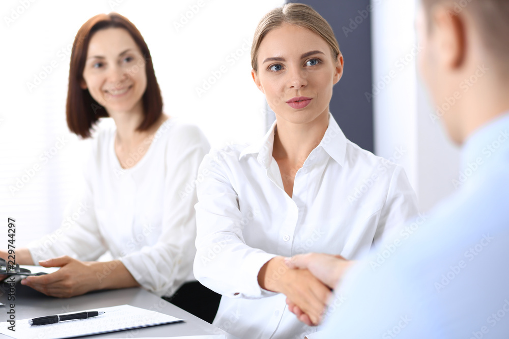 Business handshake by blonde woman and her partner at meeting. Concept of success and agreement Business handshake by blonde woman and her partner at meeting. Concept of success and agreement