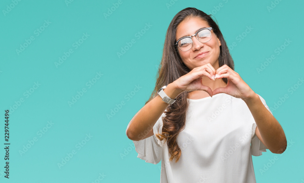 Fototapeta premium Young beautiful arab woman wearing glasses over isolated background smiling in love showing heart symbol and shape with hands. Romantic concept.